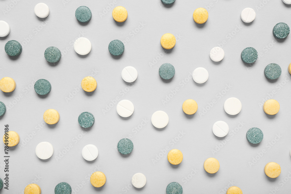 Different colorful pills on grey background