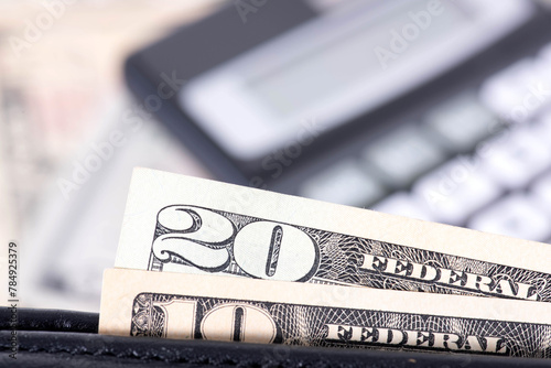 Dollar bills, wallet and a calculator