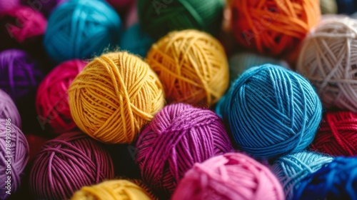 Many colorful yarn balls are sitting in a pile