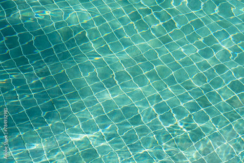  Water surface with waves on water surface wave effect You can see the blue square tiles at the bottom of the pool.	 photo