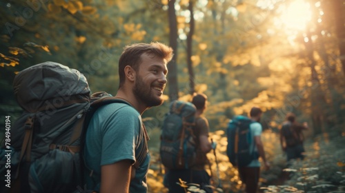 Happy backpacker and his friends hiking in forest photo