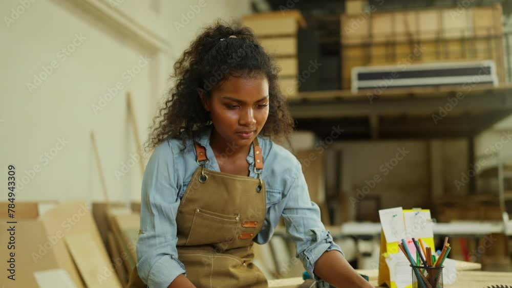 Professional carpenter or woodworker or charpentier woman check wood product on table then look at camera with smiling in workplace.