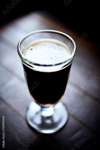 Glass of dark beer on dark wooden background. close up