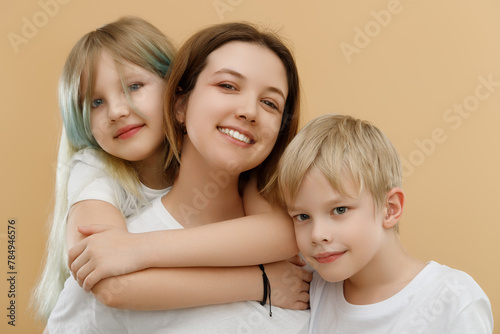 Happy people. Mother's Day. Mother hugging her cute children . Happy loving family. Mother and her children girl and boy playing and hugging. Brother and sister. 