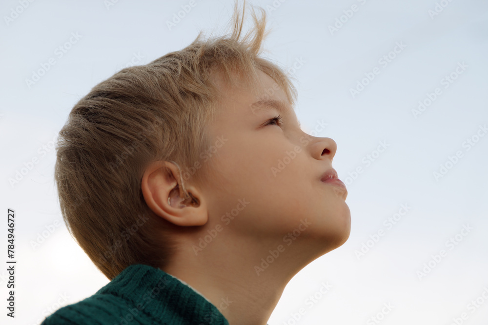 A boy with a hearing aids on blue background. A boy with a hearing aids on blue background.