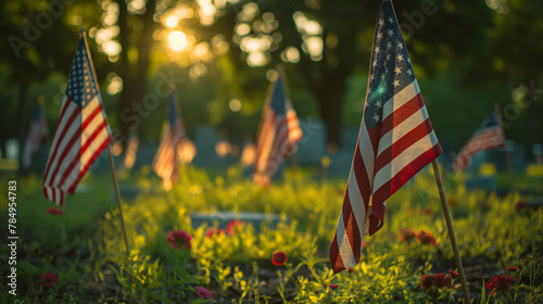 American flags marking graves in a field at sunset, a symbol of remembrance. photo