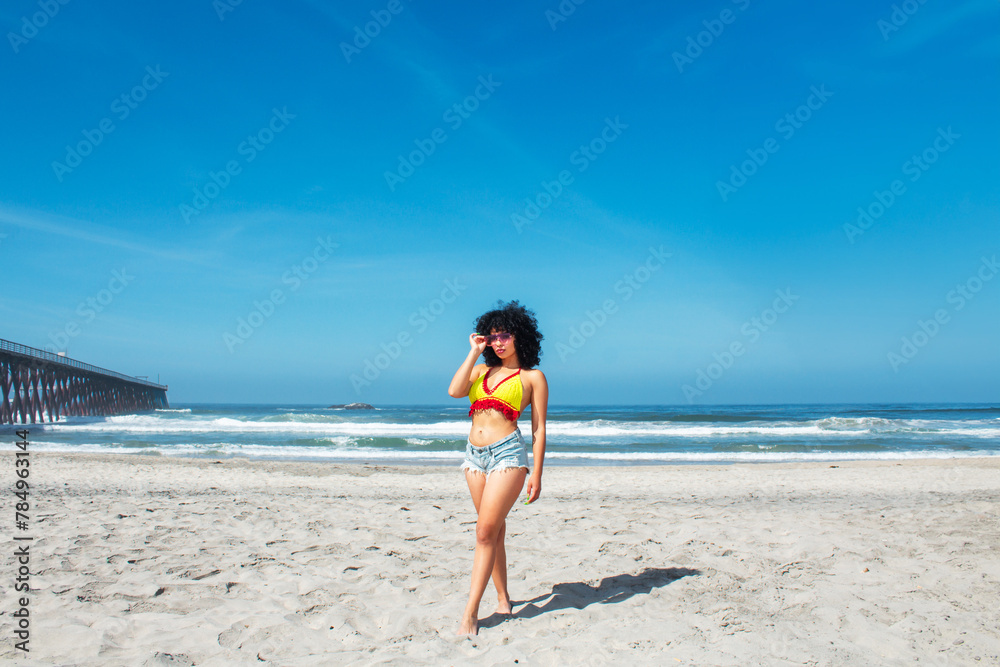 beautiful african american woman on mexican rosarito beach wearing shorts and bikini standing next to pier, latina beautiful african american woman on mexican rosarito beach wearing shorts and bikini standing next to pier, latina