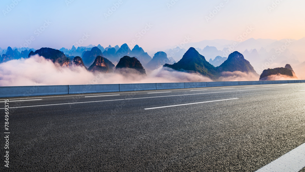 Naklejka premium Asphalt highway road and karst mountain with fog natural landscape at sunrise