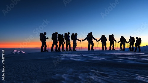 The moment of achievement captured as a group stands hand-in-hand on the summit, their shadows stretching long into the twilight.