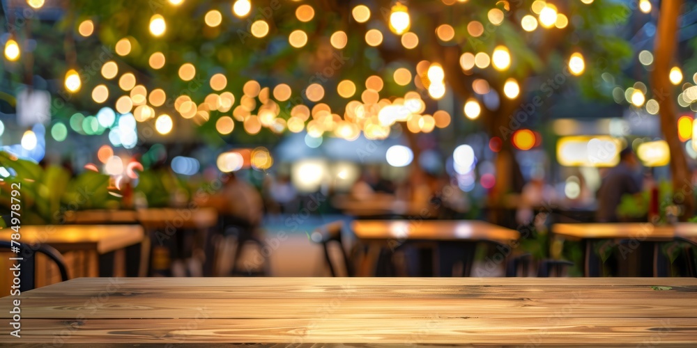 Blurred background of an inviting outdoor cafe decorated with glowing string lights and cozy dining atmosphere.