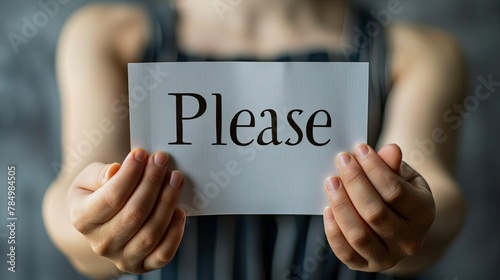 A woman holding a sign that says "Please".