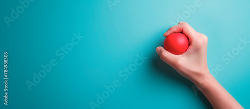 Photo of a hand squeezing a stress ball with copy space on the right photo
