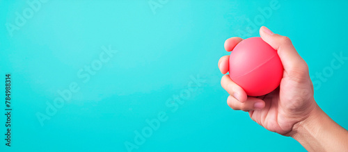 Photo of a hand squeezing a stress ball with copy space on the right photo