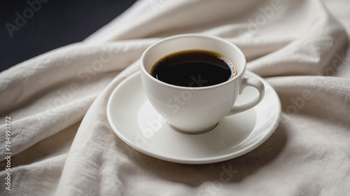 Cup of warm coffee on white bed linen. Cozy and lazy morning at home while having breakfast in bed. Hygge concept