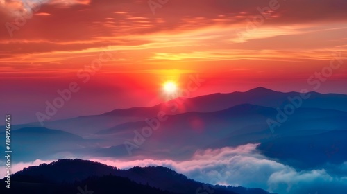 The sun sets behind the distant mountains, The clouds in front create an ethereal mist. Majestic mountain range, with rolling hills bathed in the golden sunlight.  © horizor