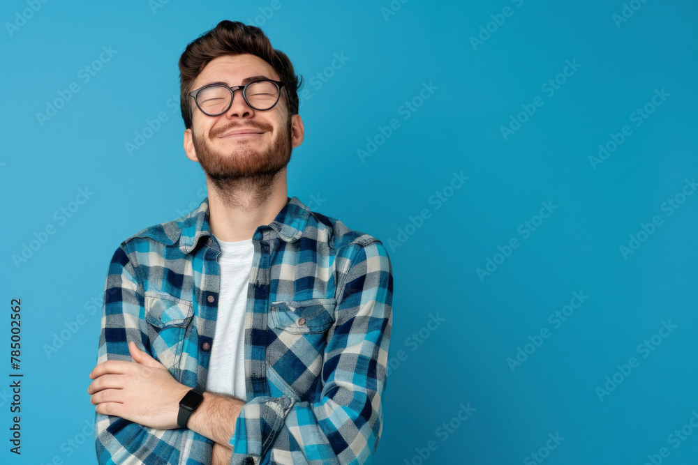 Fototapeta premium Portrait of a handsome young man in a glasses with a crossed arms in a studio plain background. AI generated