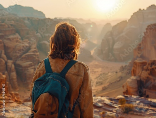 A person with a backpack standing in the desert looking at mountains.