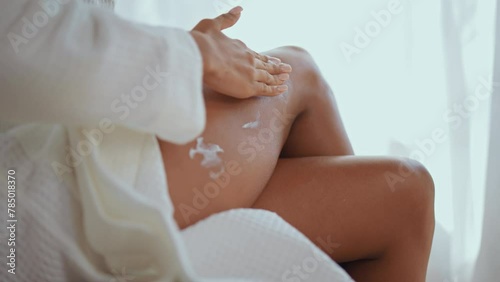 Woman applying body care lotion in bedroom beauty routine in the morning slow motion 