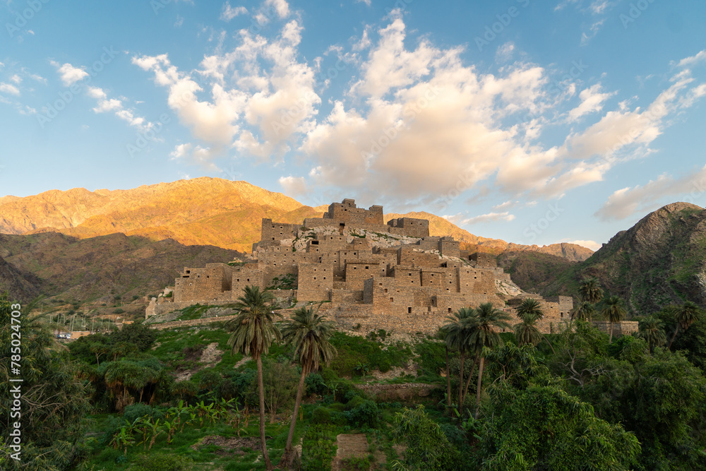 Thee Ain ancient village near Al-Bahah and Jeddah in Saudi Arabia with palm trees contrasting with desertic mountain in the Middle East
