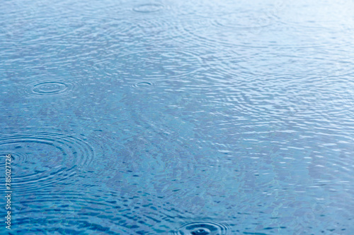 Round droplets of water over circles on pool water.