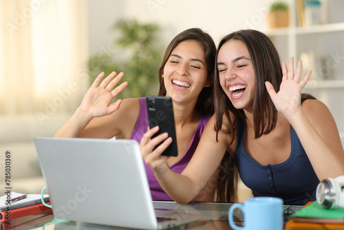 Two happy students having video call on phone