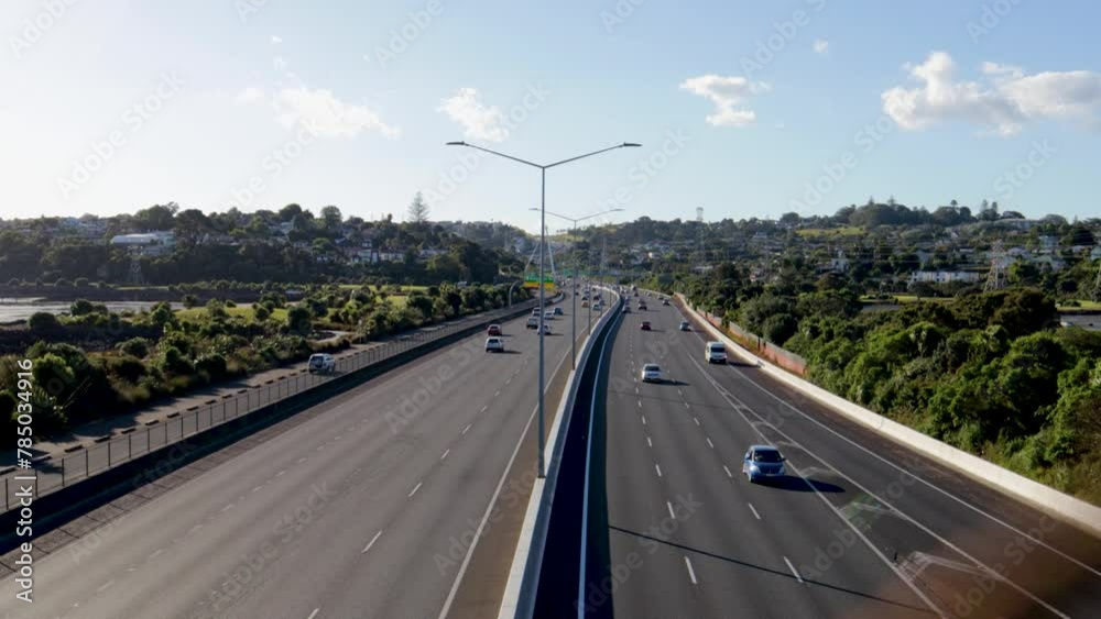 A handheld shot of the Auckland motorway in New Zealand being traversed by several vehicles at high speed on a sunny afternoon with some clouds. A handheld shot of the Auckland motorway in New Zealand being traversed by several vehicles at high speed on a sunny afternoon with some clouds.