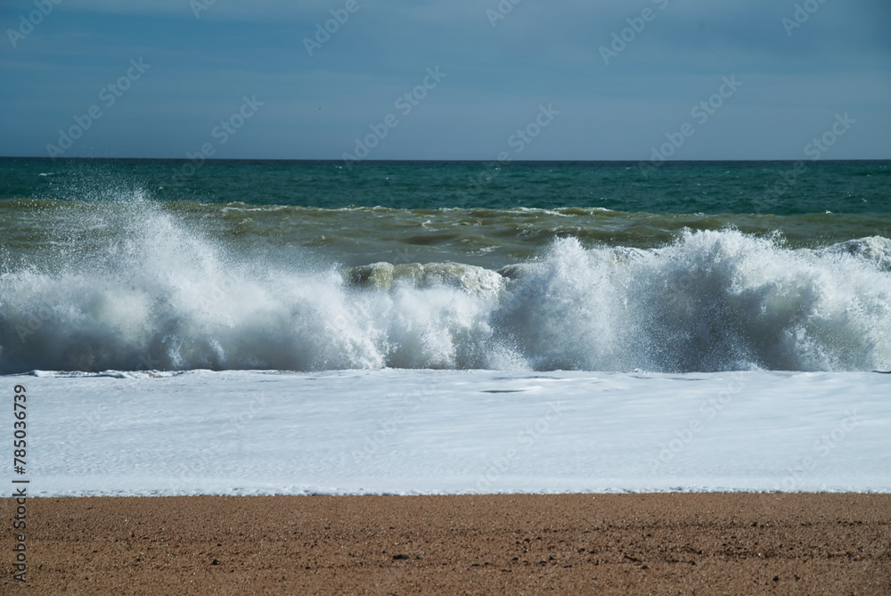 Fototapeta premium Wave of foam breaking towards the sand of the beach.