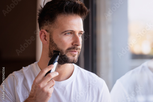 Man using electric razor and shaving his face