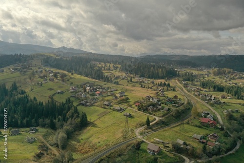 Aerial view of beautiful forest and mountain village on autumn day