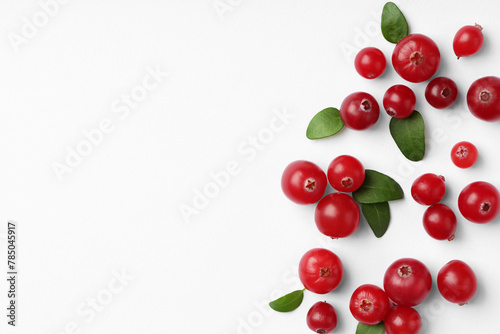 Fresh ripe cranberries and green leaves on white background, flat lay. Space for text