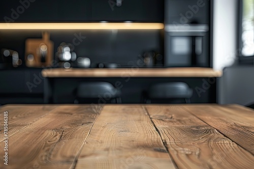 A copy space on a hardwood dining table in a modern black kitchen with kitchen appliances 