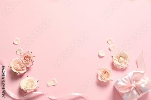 Happy Mother's Day. Beautiful flowers, gift box and ribbon on pink background, flat lay. Space for text
