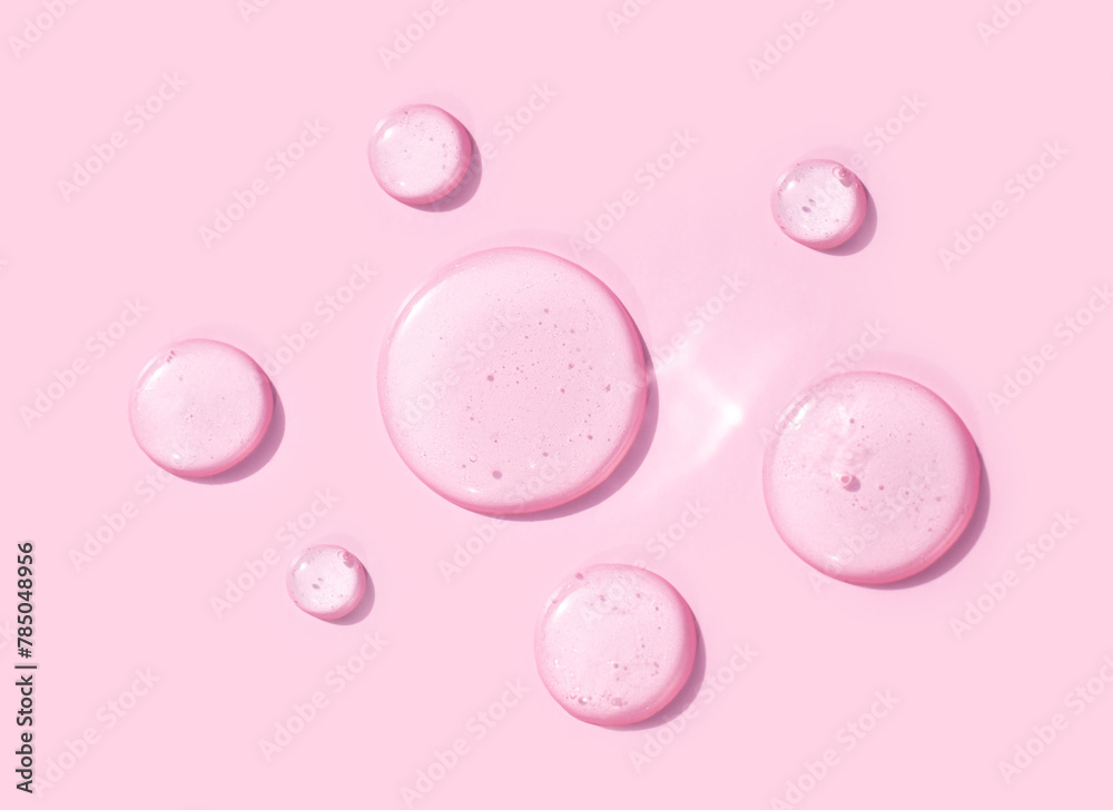 round drops of transparent gel serum on pink background round drops of transparent gel serum on pink background