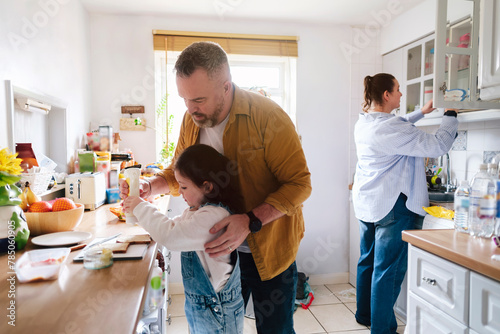 Father and daughter preparing sandwich in kitchen at home photo