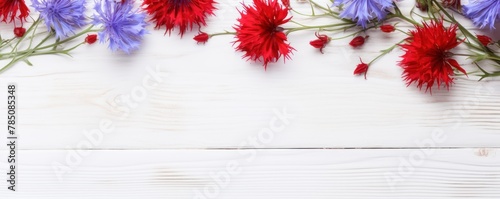 Beautiful red cornflower flowers on a white wooden background  in a top view with copy space for text