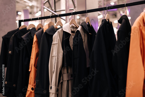 Black orange fashion cloth hanging on a hangers in a row. Modern clothing collection