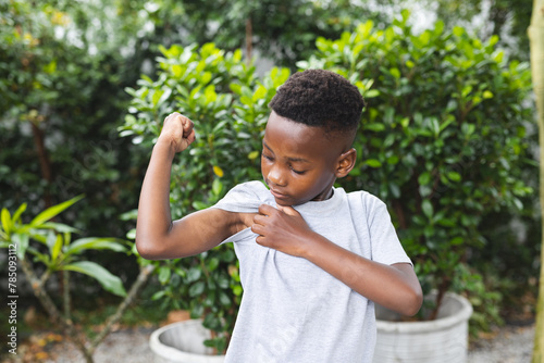 African American boy showing off muscles, in backyard at home photo