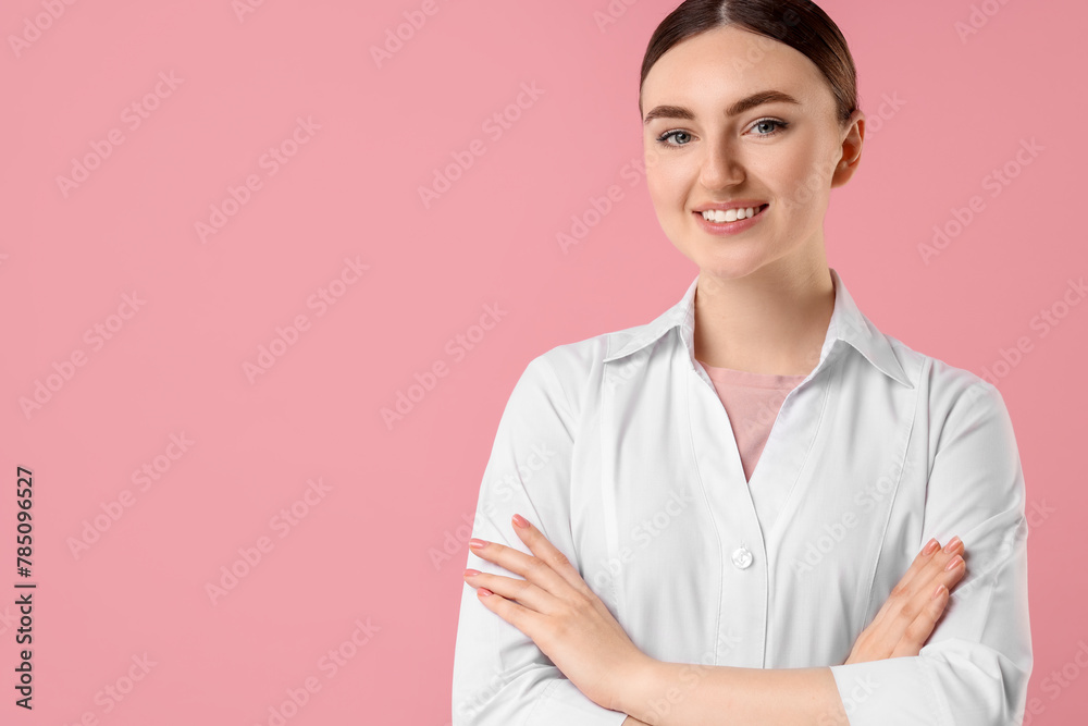 Cosmetologist in medical uniform on pink background, space for text