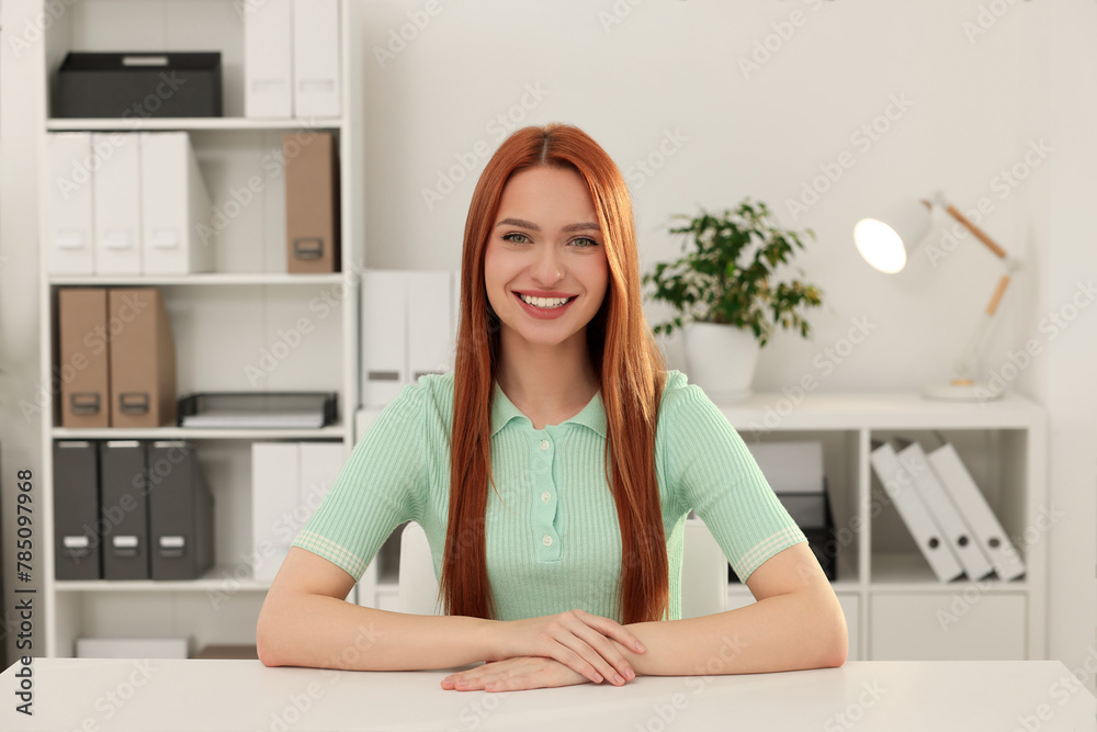 Young woman having video chat at table in office, view from web camera Young woman having video chat at table in office, view from web camera