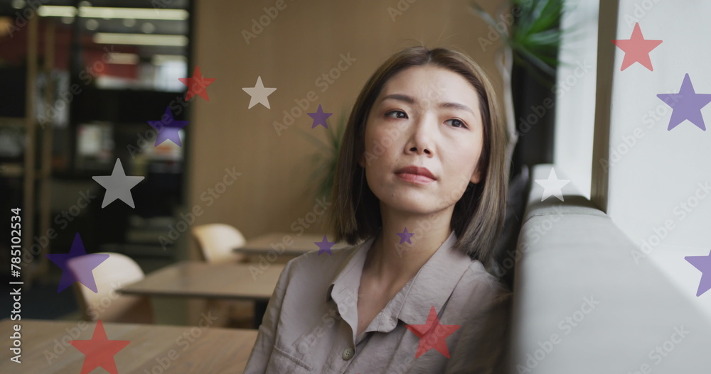Fototapeta premium Image of stars of flag of usa over asian businesswoman in office