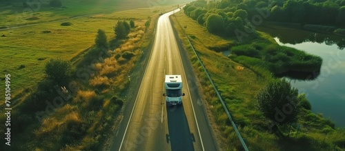 Aerial view of motorhome driving through empty road in scenic green valley landscape