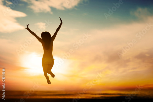 Silhouette of Happy carefree woman wearing bikini jumping on beach