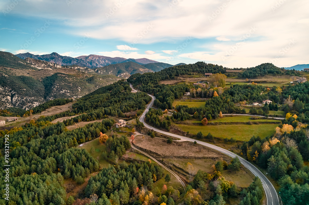 Aerial view of winding mountain road with clouds and trees