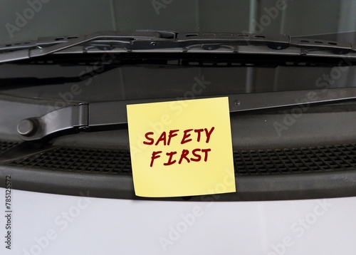 Note stick on car with handwritten text  SAFETY FIRST , to remind driver to drive carefully with awareness behind steering wheel