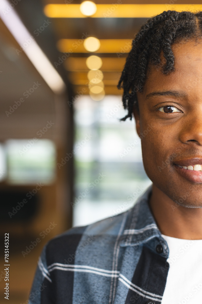 Fototapeta premium African American man standing indoors in a modern business office, looking at camera with copy space