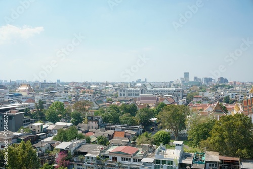 Drone shot of Bangkok cityscape with trees and blue sky