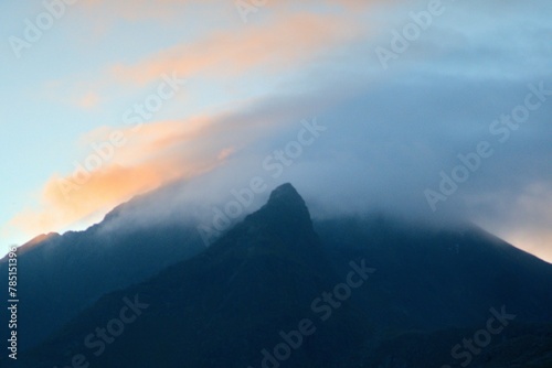 Scenic shot of clouds above mountain silhouettes during sunset