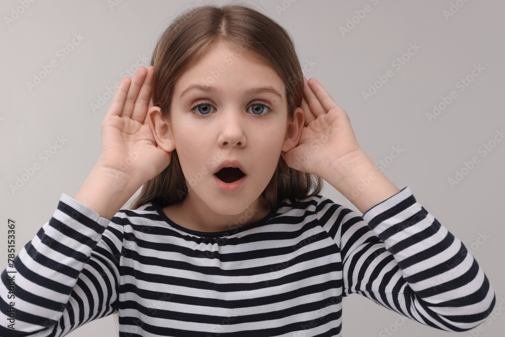 Little girl with hearing problem on grey background Little girl with hearing problem on grey background