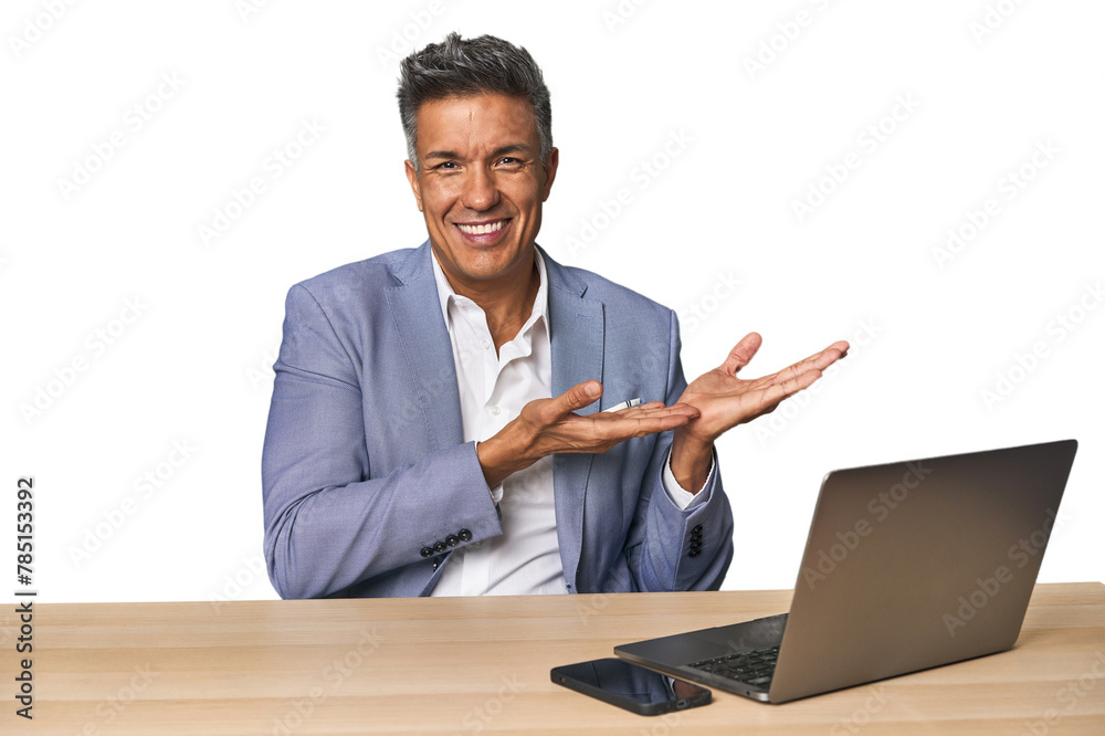 Elegant businessman at desk with laptop holding a copy space on a palm. Elegant businessman at desk with laptop holding a copy space on a palm.
