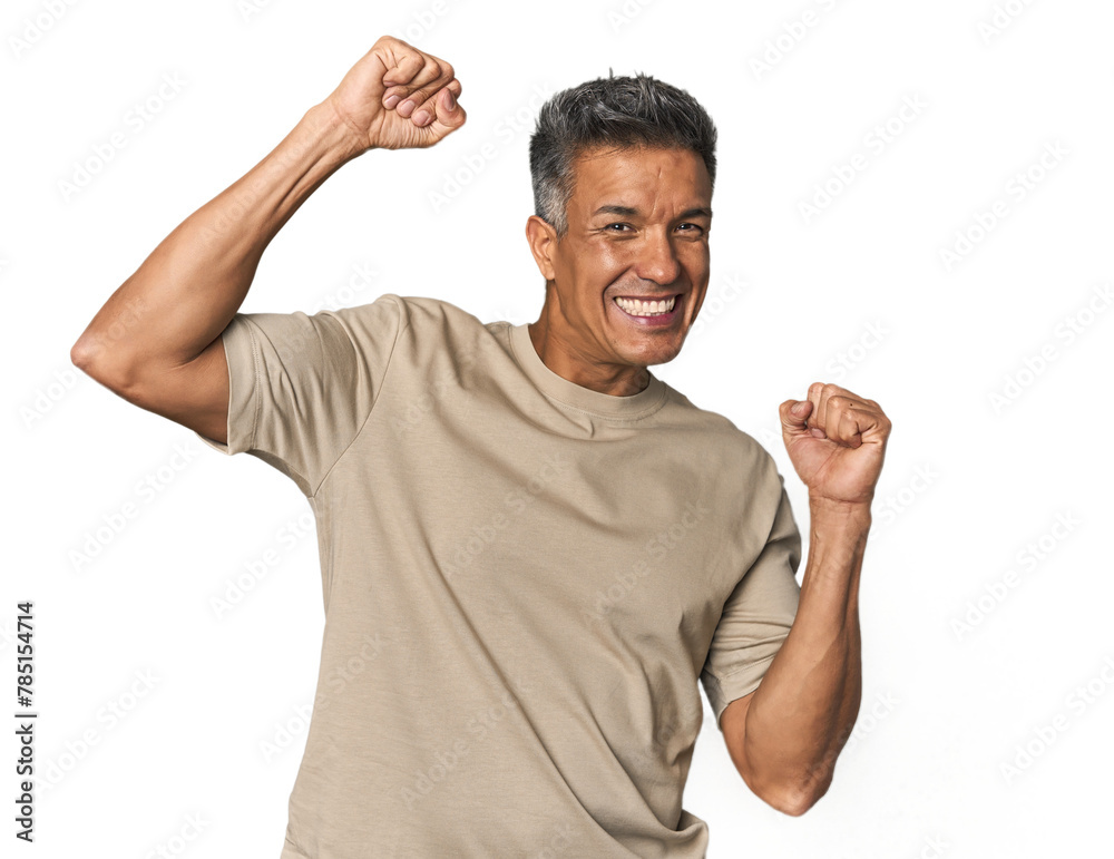 Middle-aged Latino man celebrating a special day, jumps and raise arms with energy. Middle-aged Latino man celebrating a special day, jumps and raise arms with energy.